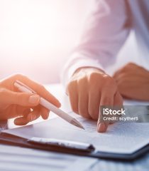 Business people negotiating a contract. Human hands working with documents at desk and signing contract.